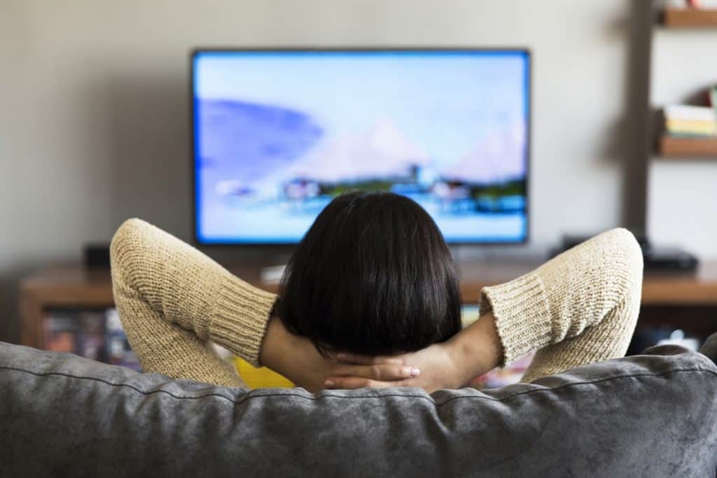mujer viendo la televisión a la distancia adecuada